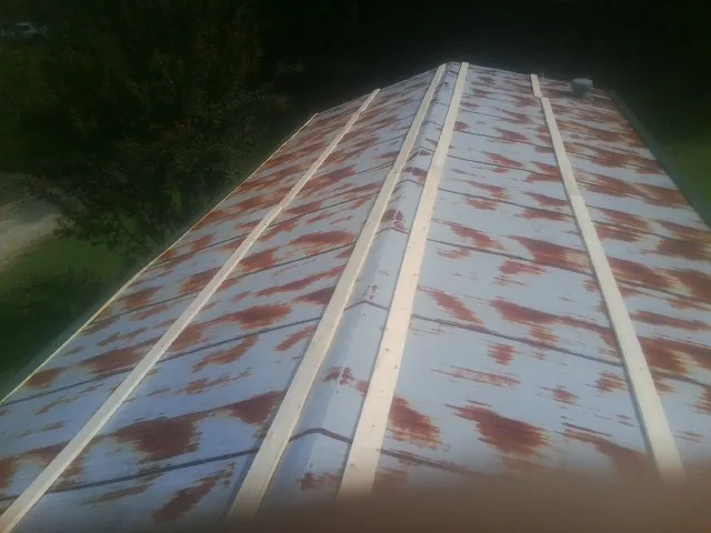 Rusted metal roof panels with new wood purlins before replacement — Storm Damage Roof Repair in Barnstable by Roofing Brothers
