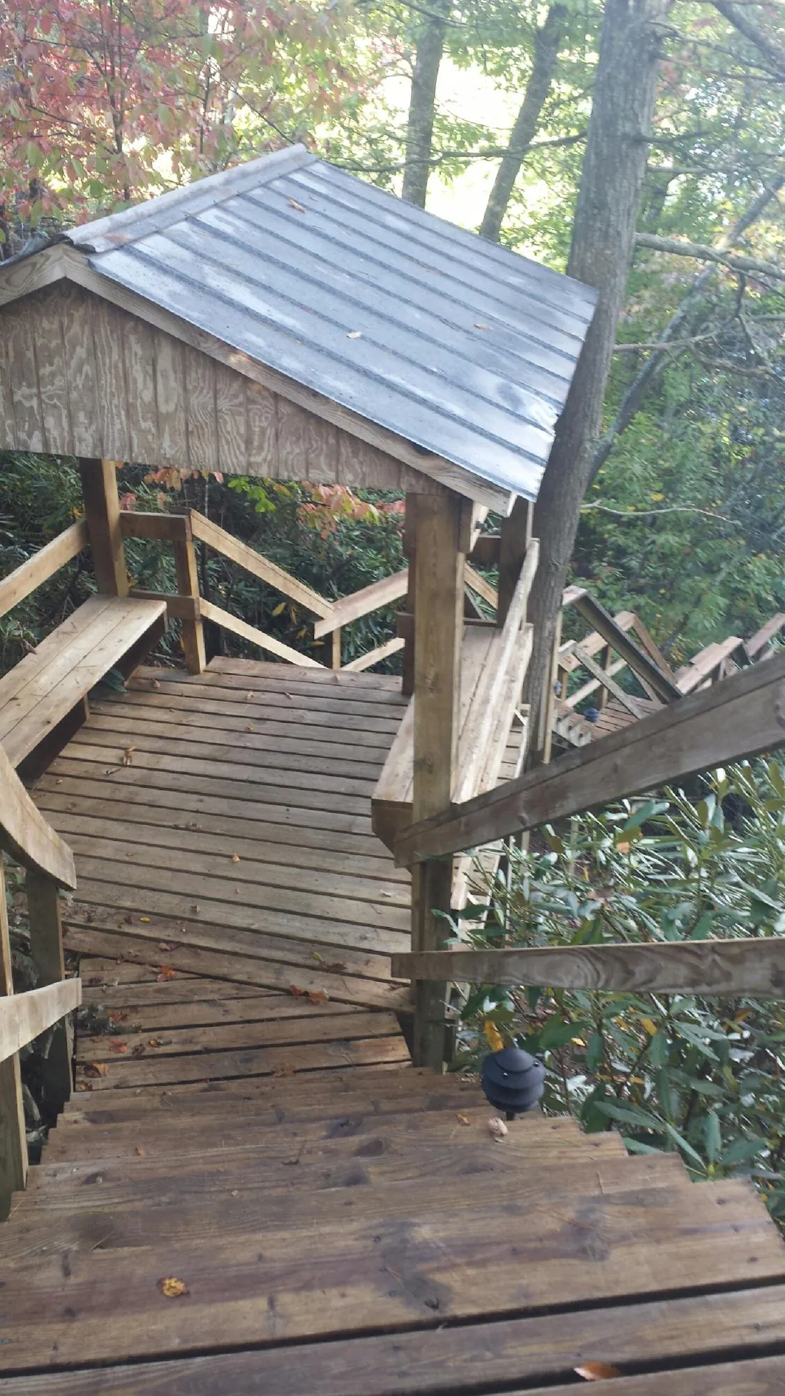 Metal roofed shelter over wooden steps on a wooded walkway — Skylight Repair & Installation work by our crew in Barnstable
