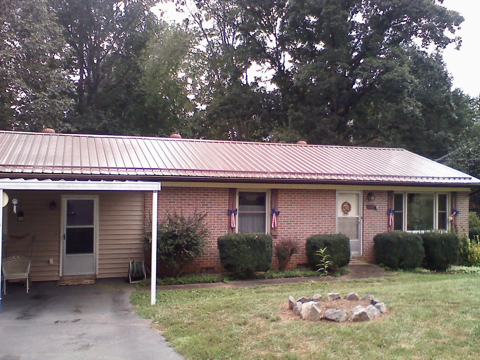 Bronze metal roof and carport on a brick ranch home — Roof Repair work by our crew in Barnstable
